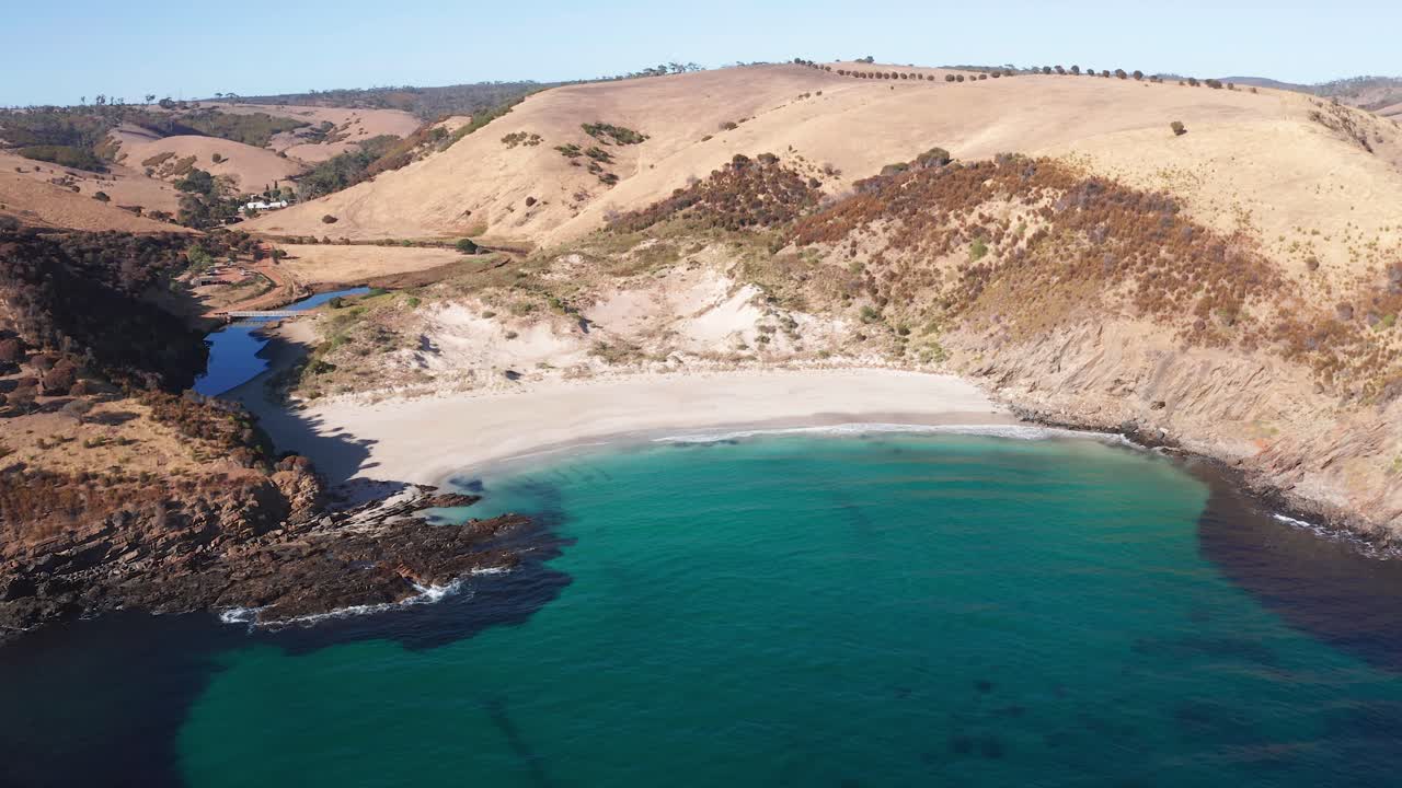 Reverse aerial reveal of white sand beach and hills at Western River Cove, Kangaroo Island, South Australia