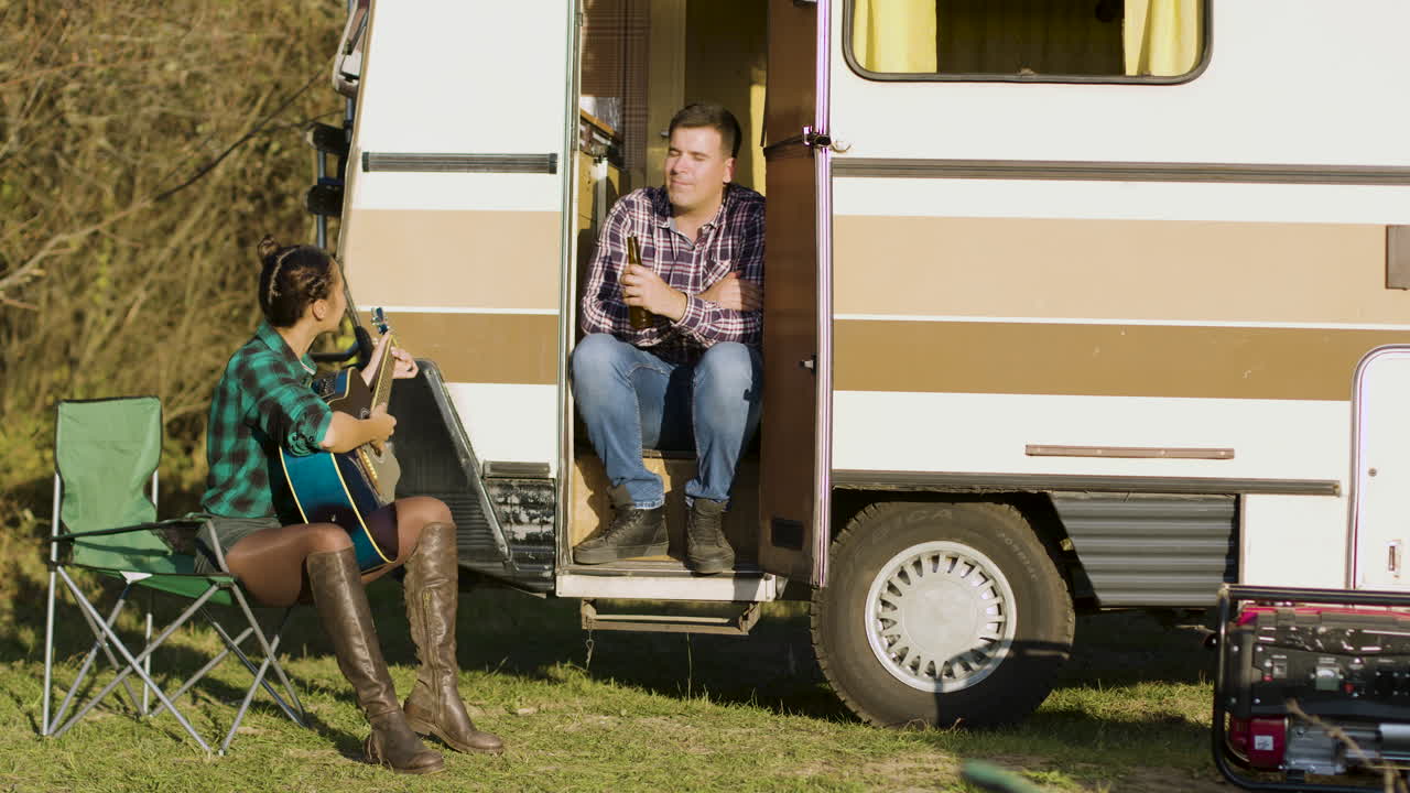 기쁜 여자 가 남자친구 를 위해 기타 로 노래 를 부르고 있다