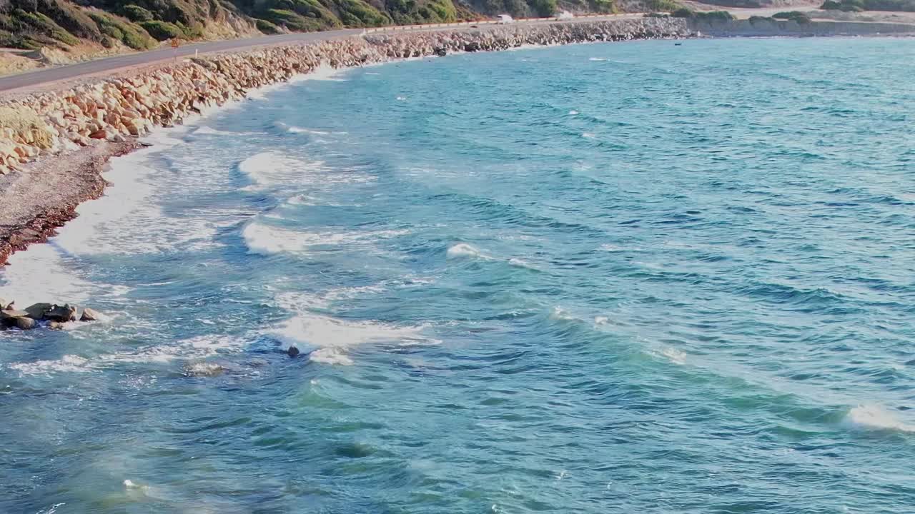Le onde si infrangono sulla costa rocciosa di Rodi, in Grecia, vicino alla strada