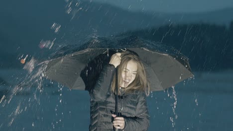 excited girl enjoys heavy rain by river at night slow motion