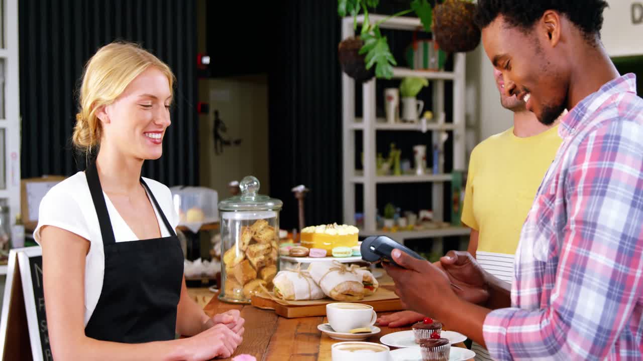 cliente que realiza un pago a través de una máquina terminal de pago en el mostrador