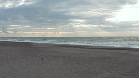 Océano-Con-Gaviotas-Volando-En-El-Norte-De-Europa-Con-Una-Impresionante-Formación-De-Nubes-Al-Atardecer,-Avance-Aéreo-Bajo