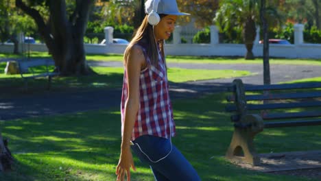 Woman-listening-music-while-playing-in-the-park-4k