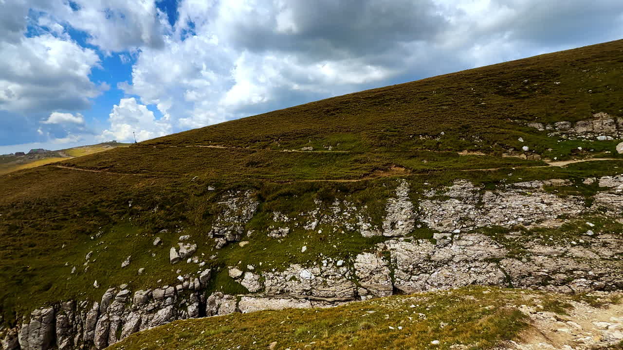 Parete rocciosa verticale di una scogliera di montagna. La texture frastagliata della pietra mostra i dettagli del terreno accidentato