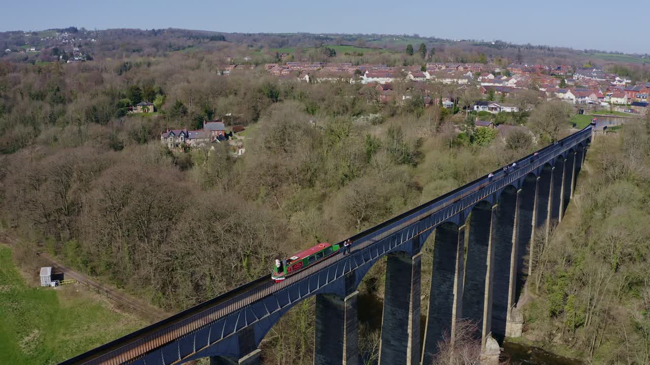 узкая лодка, пересекающая акведук pontcysyllte, знаменитый по проекту томаса телфорда, расположенный в живописной сельской местности уэльса, знаменитый маршрут канала