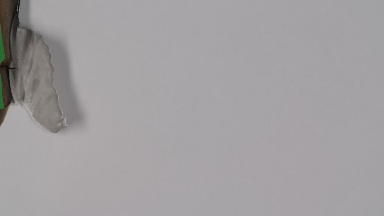 пламя сжигает белый пустой лист бумаги на зеленом экране хроматической клавиши. огонь выжигает край бумаги, превращая его в пепел. идеально подходит для красивых переходов видео.