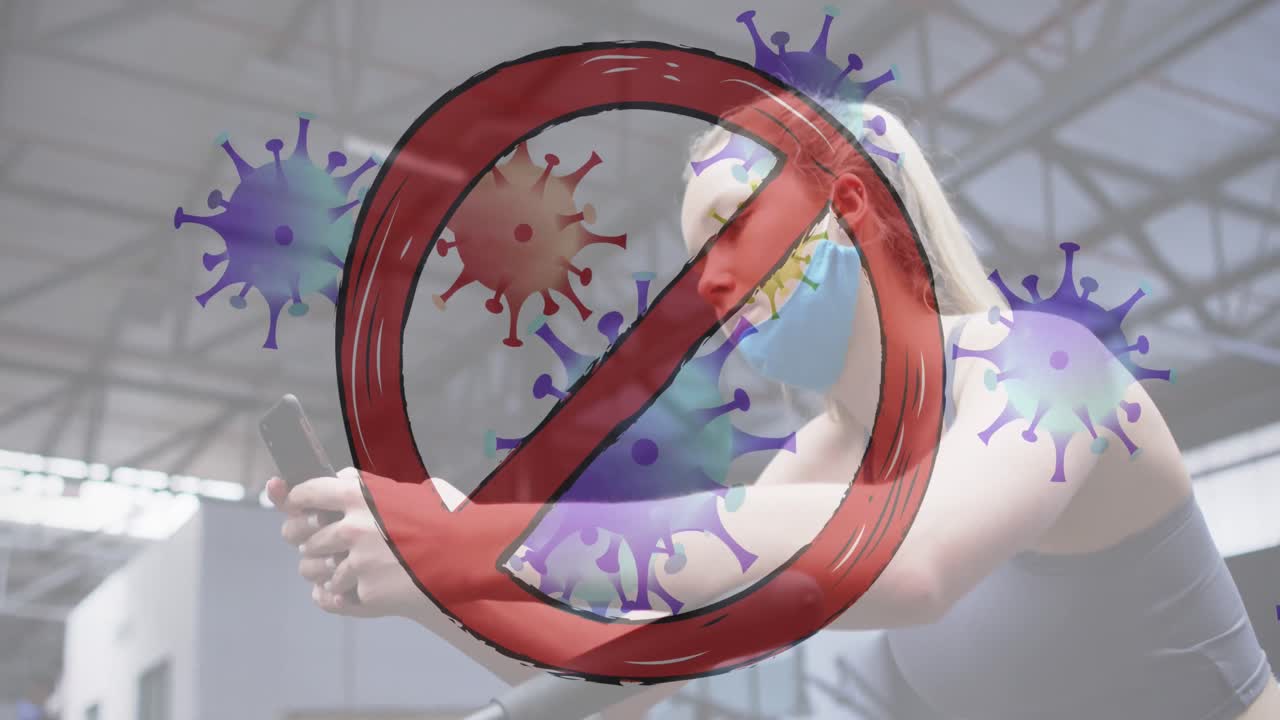 체육관에서 스마트폰을 사용하는 백인 여성을 상대로 움직이는 코로나19 세포를 중단하십시오.