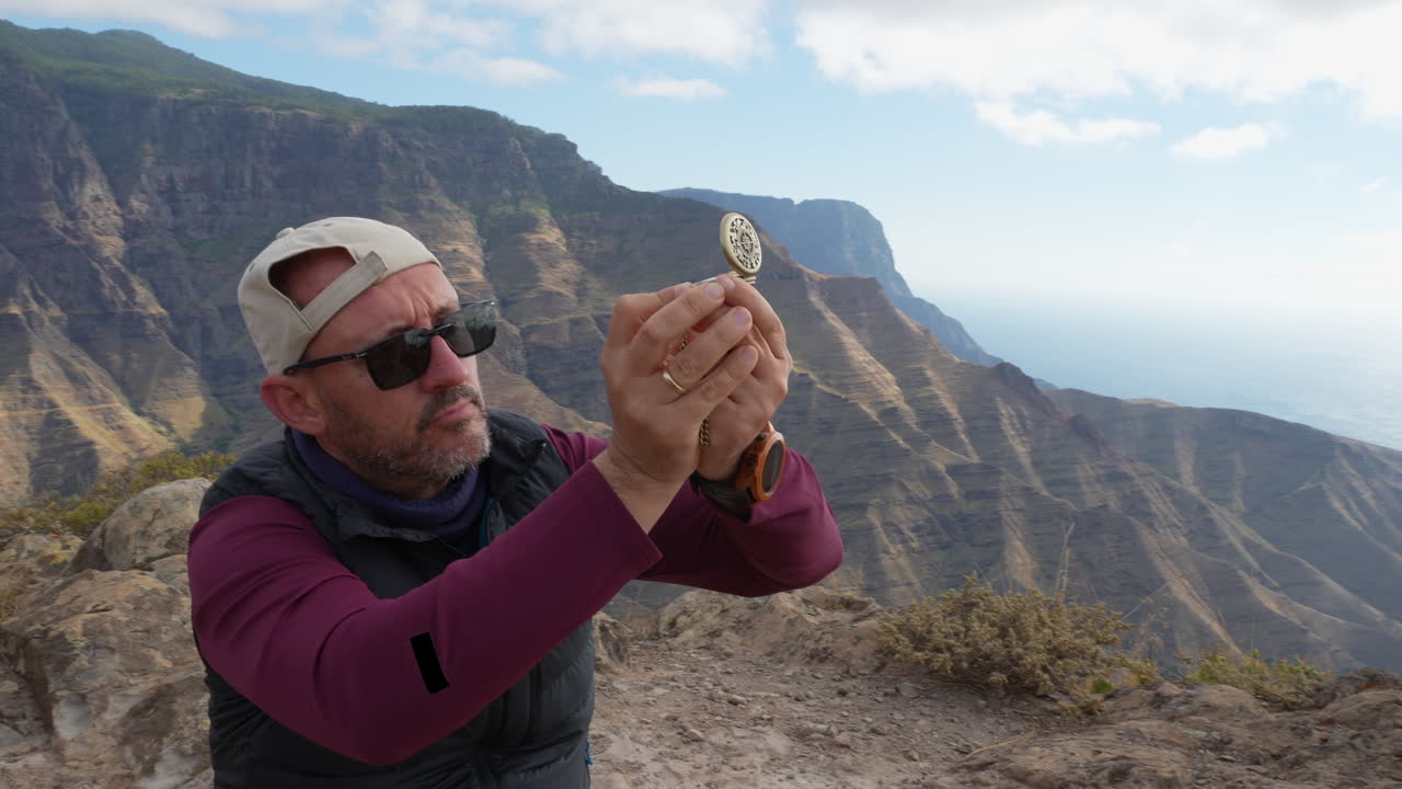 Mountain hiker using compass for orientation.Gran Canaria, Canary Islands.