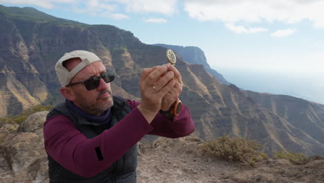 mountain hiker using compass for orientation.gran canaria, canary islands.
