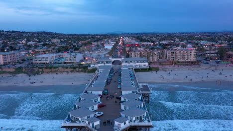 Drone-Volando-Hacia-Atrás-Sobre-El-Muelle-De-Cristal-En-Pacific-Beach,-Una-Comunidad-Costera-En-San-Diego,-California