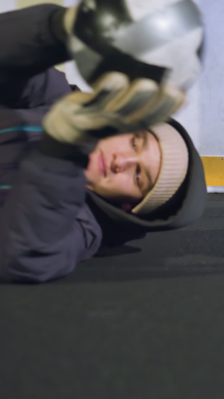 el portero se sumerge bajo a la izquierda para atrapar una pelota de fútbol durante una sesión de práctica dinámica, mostrando precisión y reflejos rápidos en un campo al aire libre bajo la iluminación brillante del estadio por la noche