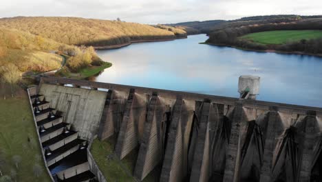 Aerial-backwards-shot-to-reveal-Wimbleball-Dam-and-Lake-England-on-a-beautiful-sunny-Autumn-evening