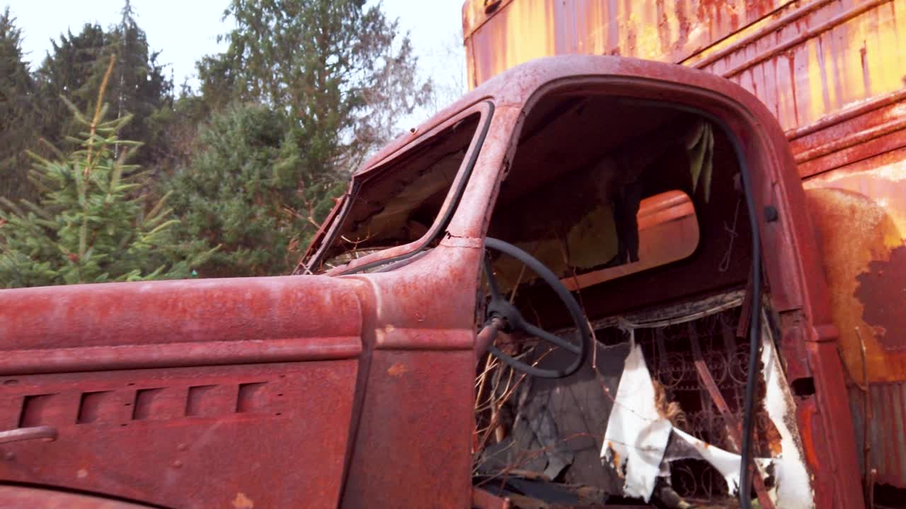Pull through an abandoned and rusted old box van truck in the middle of the woods