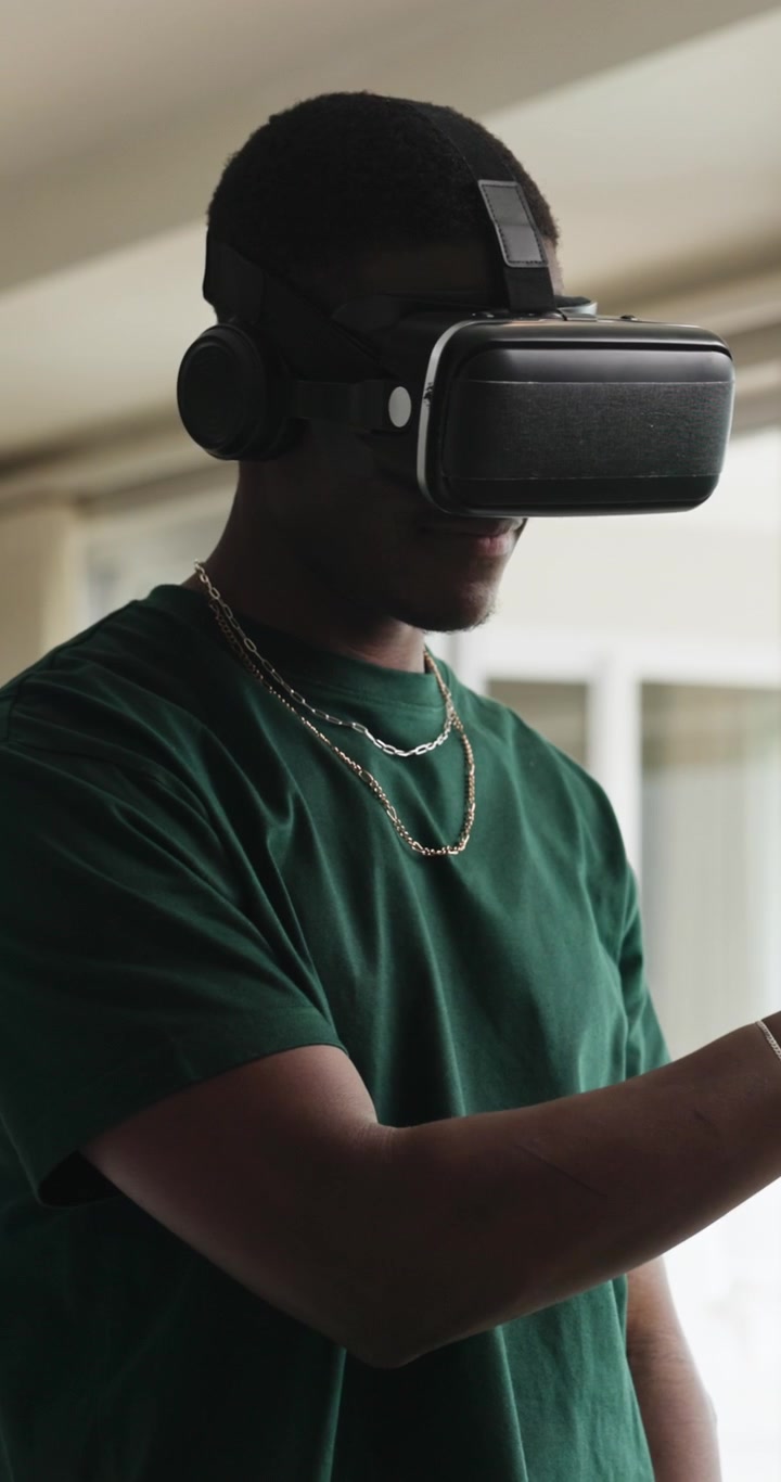 Giovane Uomo che Usa un Visore per Realtà Virtuale in un Ambiente Interno