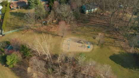 Aerial-view-of-a-small-park-surrounded-by-trees,-homes-and-bushes