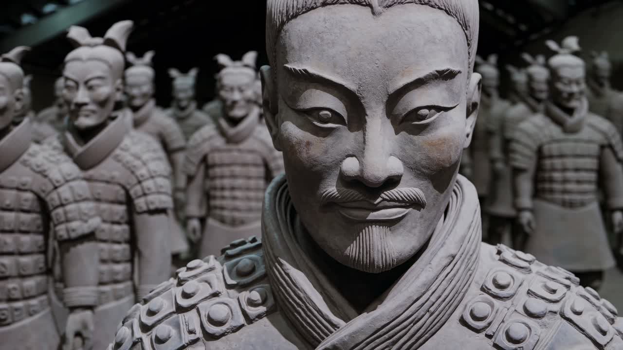 Low-angle video shot of ancient terracotta warriors in a dimly lit museum, showcasing the detailed