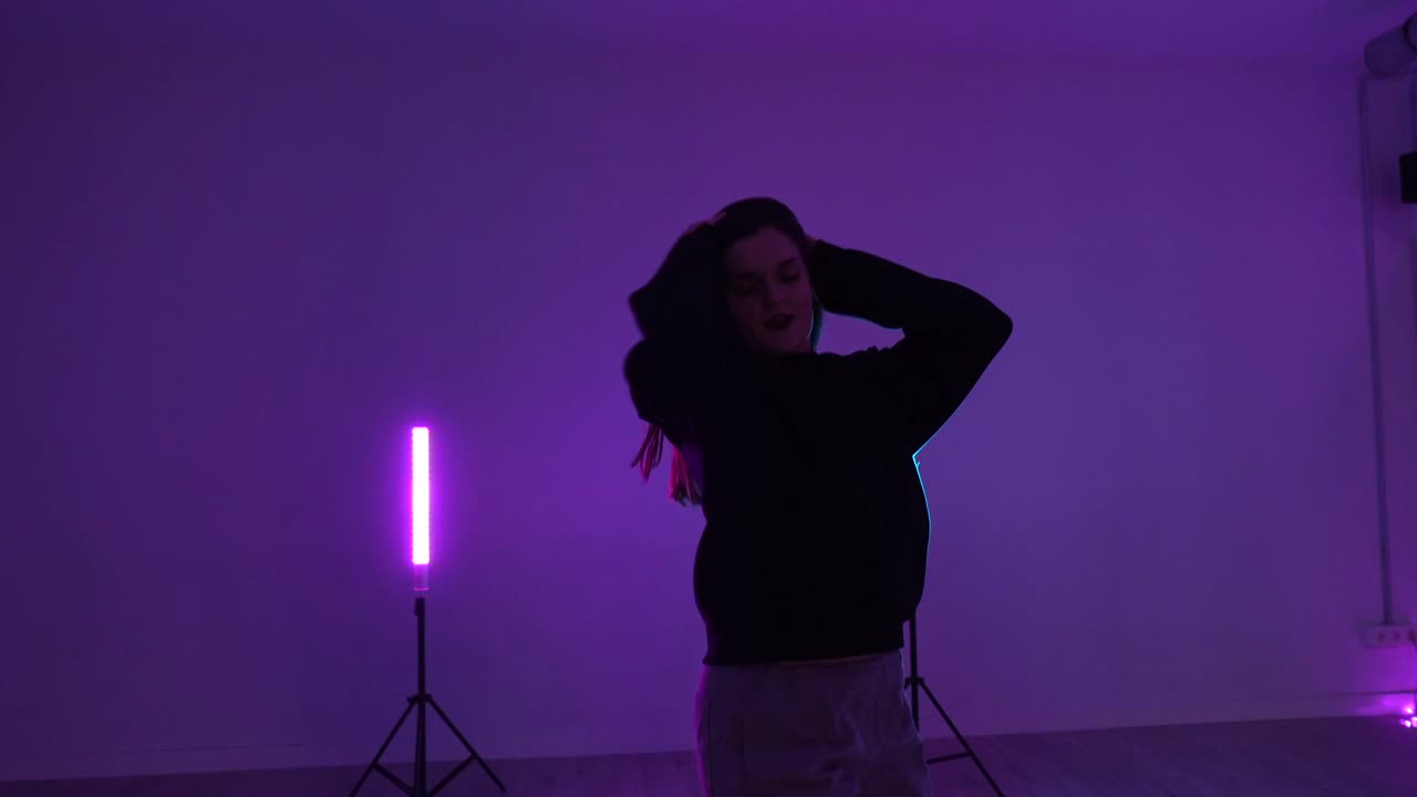 Woman dancing in a studio with neon lights