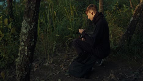 teenager taking pictures in the forest