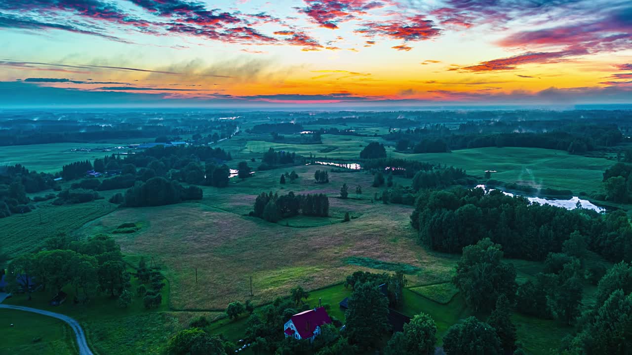 Timelapse of sunset spreading light across rural farmland and small ponds