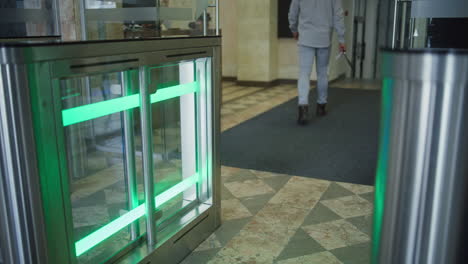 Man walking through a modern security gate in an office building