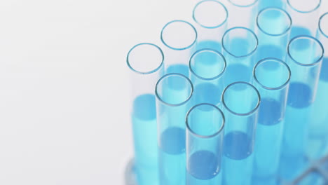 vídeo de tubos de ensaio de laboratório de vidro com líquido azul com espaço de cópia em fundo branco