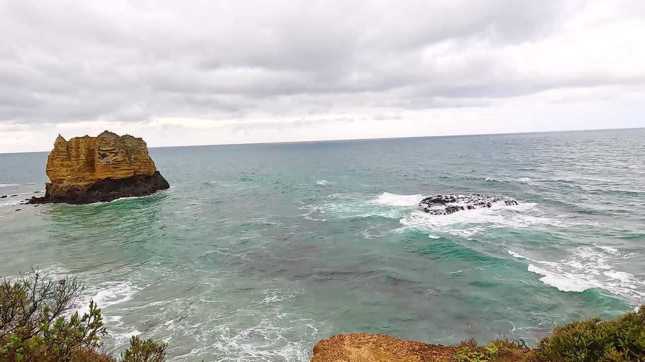 Tourists admire the rugged coastline and ocean views at Aireys Inlet, Victoria, under overcast skies