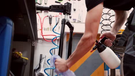 anonymous male mechanic washing bicycle fork