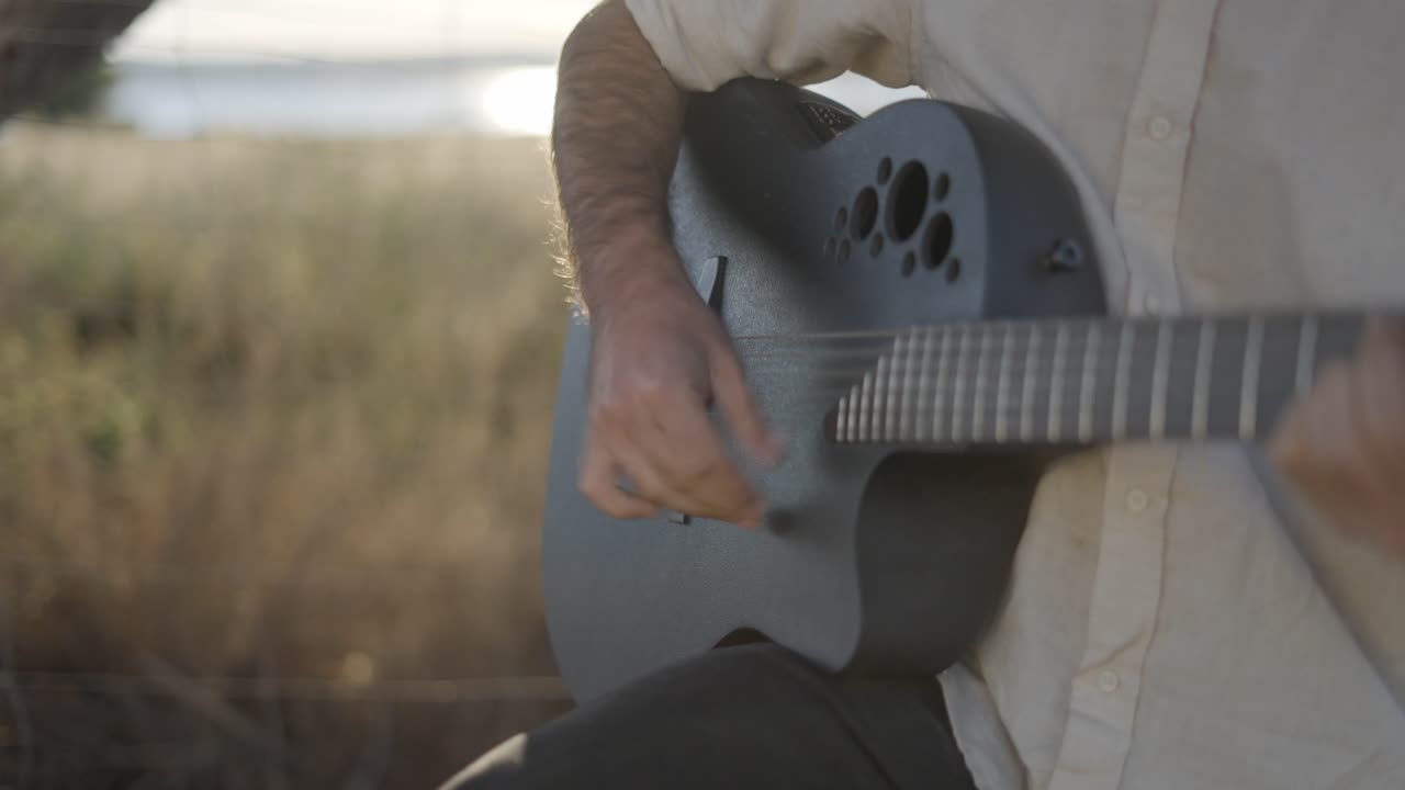 hombre tocando la guitarra acústica al aire libre