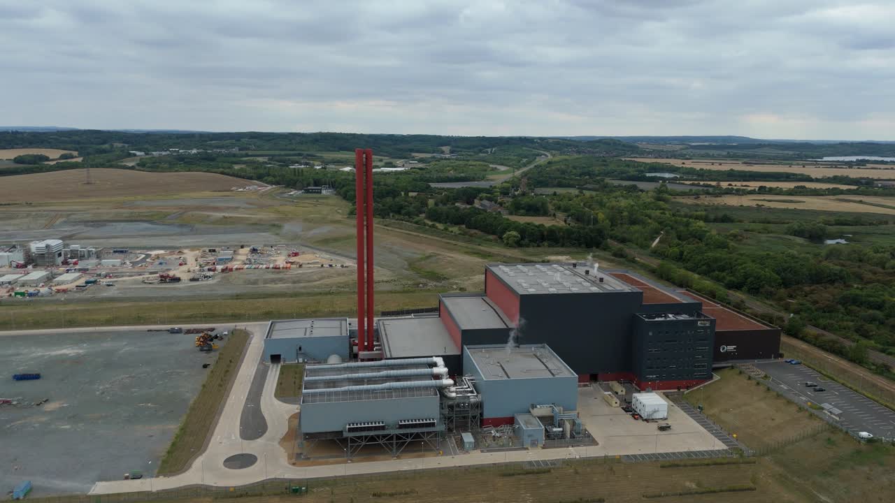 Aerial panorama of Bedford England power plant showing huge chimney stacks, industrial cooling facilities and fossil fuel energy generation systems