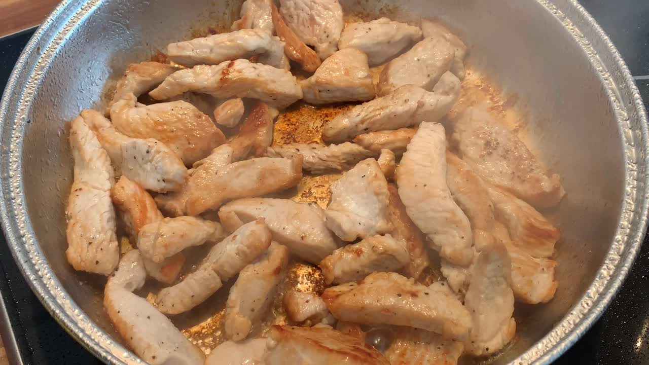 tiras salteadas de carne en una sartén en una estufa eléctrica