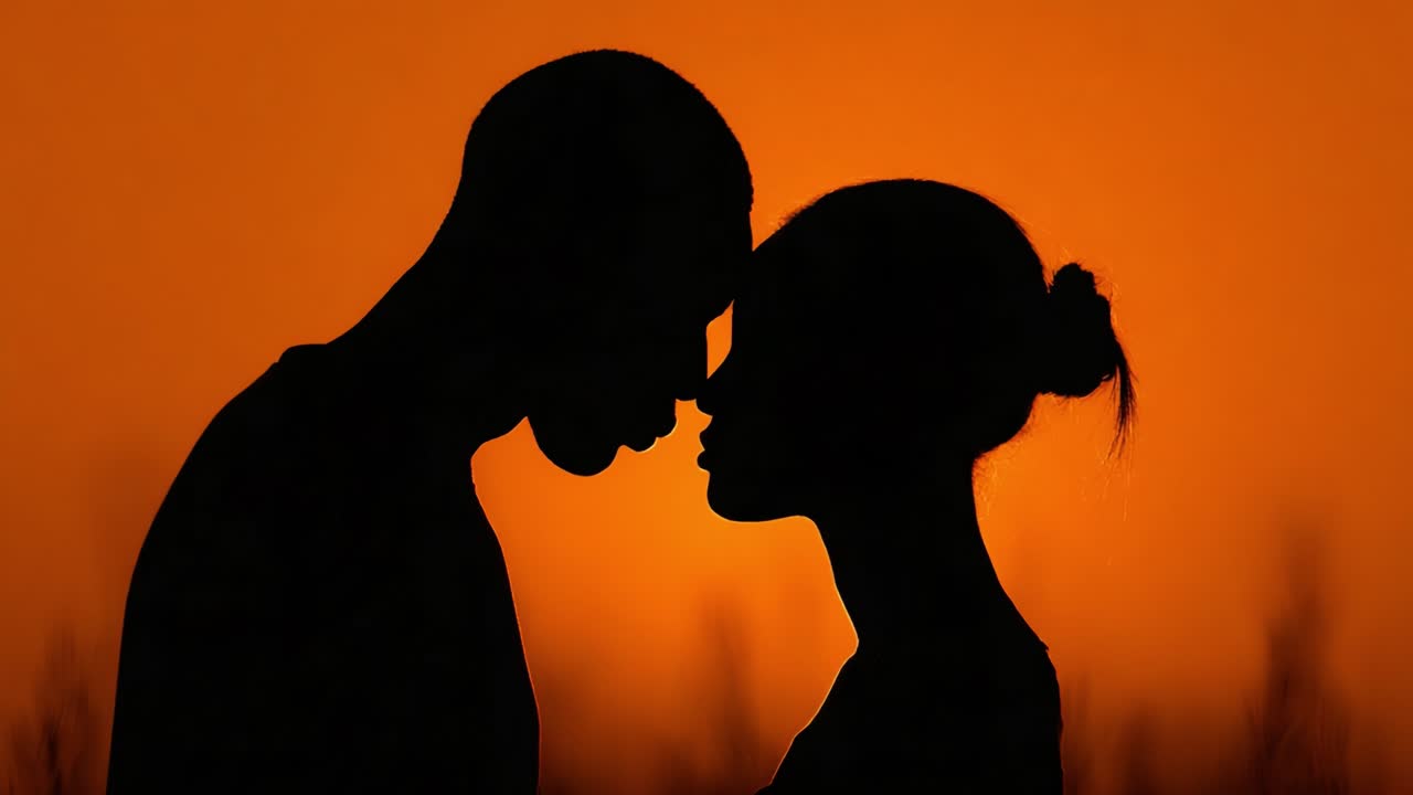 A Romantic Silhouette Embracing the Sunset: Capturing the Intimacy and Connection Between Two Lovers Against a Beautiful Orange Horizon
