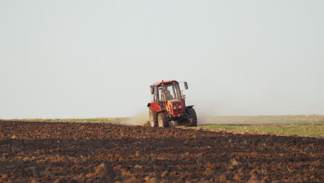 tractor plowing fields, preparing land for sowing. farmer in tractor preparing land in farmlands outdoors. agricultural industry.