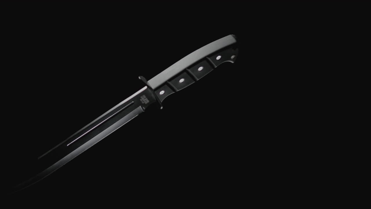 Knives on the dark background rotate in slowmotion