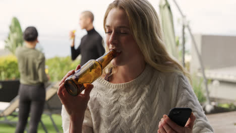 joven mujer caucásica bebiendo una cerveza en un techo