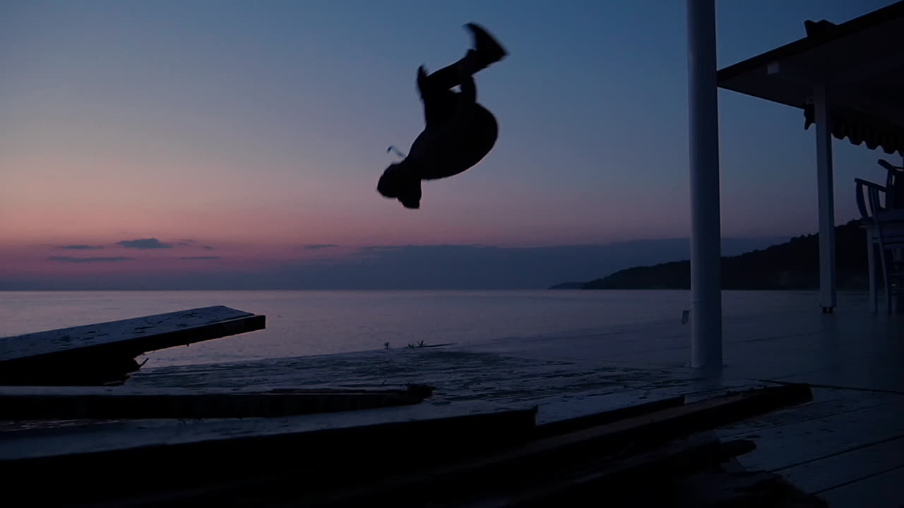 joven viajero haciendo un frontflip en la playa