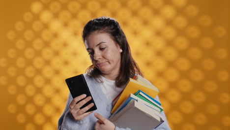mujer molesta sosteniendo una pila de libros, preparándose para el examen escolar usando el teléfono