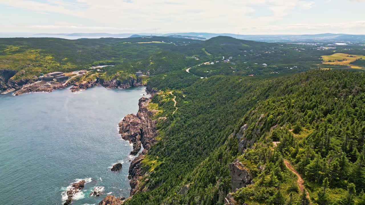 A drone soars over Red Cliff's rolling hills and farmland, revealing dramatic coastal cliffs dropping into the blue Atlantic and lush forests