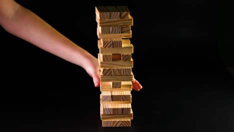 hand removes block, tower collapses