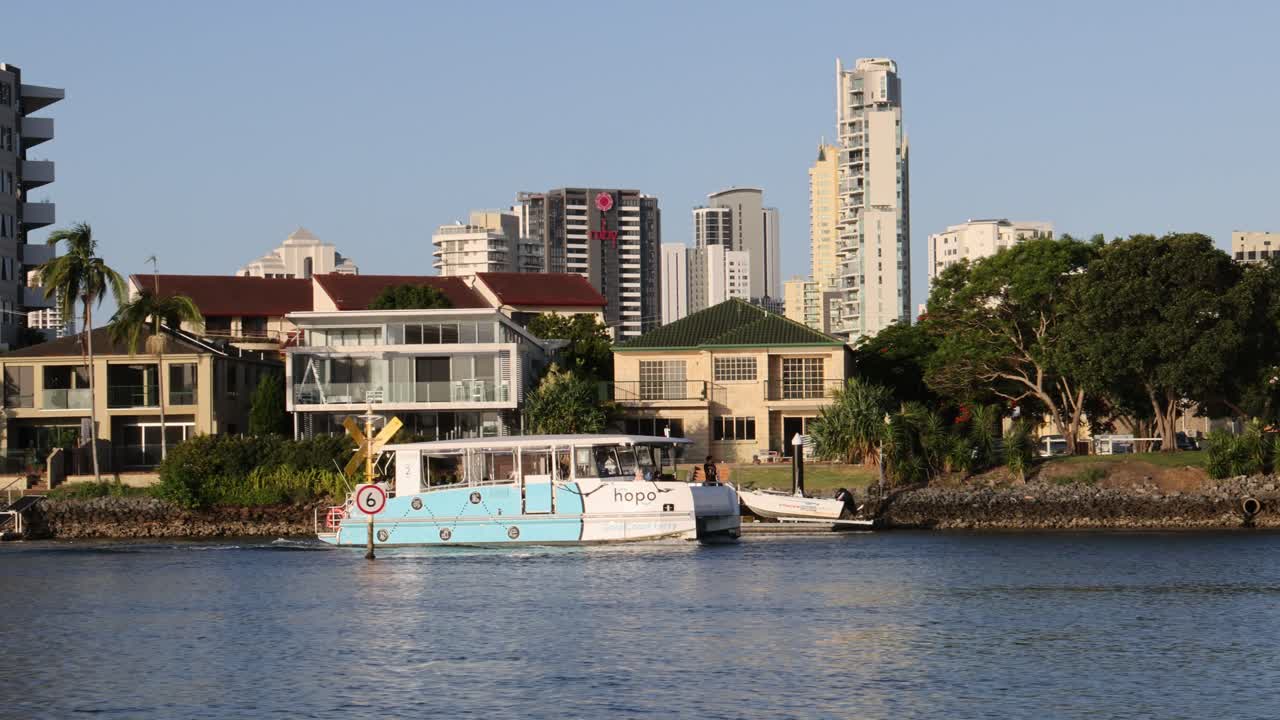 페리가 경치 좋은 도시 강변을 가로질러 이동합니다.