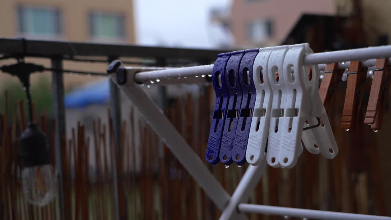 Detailed shot of water droplets on pegs and railing, evoking a peaceful and reflective rainy-day mood
