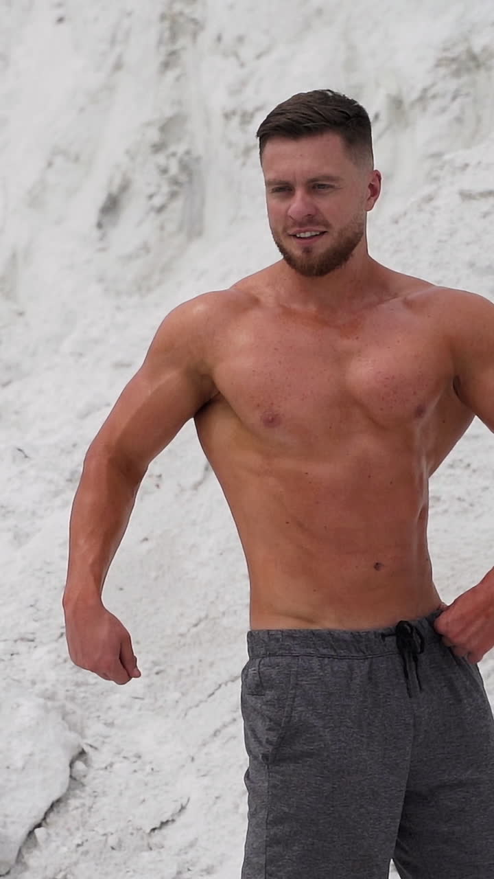 Athletic man standing with naked torso. Strong sportsman with naked torso showing muscular body. Vertical video