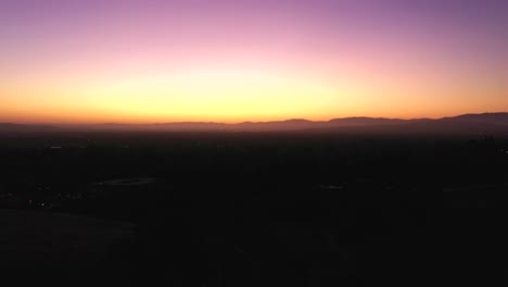 Atemberaubender-Sonnenaufgang-Vor-Morgengrauen-Mit-Violetten,-Blauen,-Orangen,-Bernsteinfarbenen-Und-Weißen-Farben-über-Einer-Rauchigen,-Taubeladenen-Landschaft