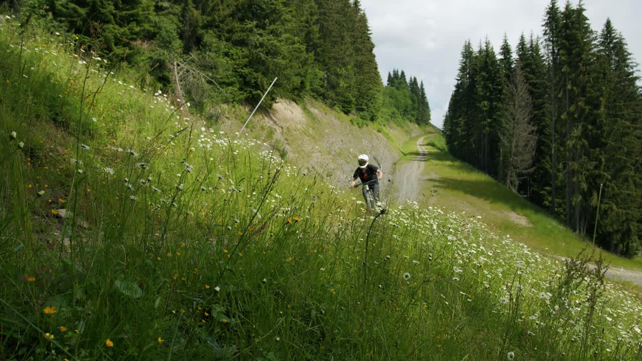 ciclista de montaña monta rápido a través de la hierba alta