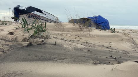 on the sandy shore, weathered fishing boats rest, capturing the rustic charm and gradual aging of village fishing equipment