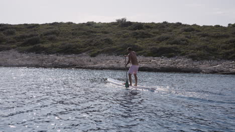man stand-up paddleboarding in the ocean