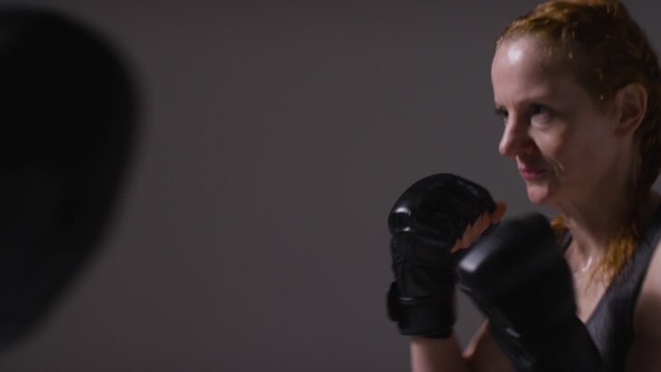 Close Up Studio Shot Of Two Mature Women Wearing Gym Fitness Clothing Exercising Boxing And Sparring Together