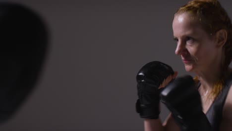 Nahaufnahme-Einer-Studioaufnahme-Von-Zwei-Reifen-Frauen-In-Fitnesskleidung,-Die-Gemeinsam-Boxen-Und-Sparring-Trainieren