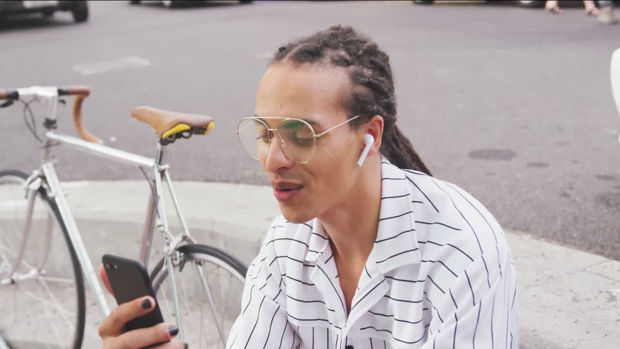 Mixed race man using his phone outside