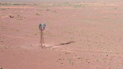 drohnenansicht auf wüstenwindmühle und trockene landschaft im australischen hinterland