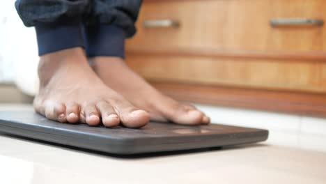 los pies del hombre en la balanza de peso de cerca